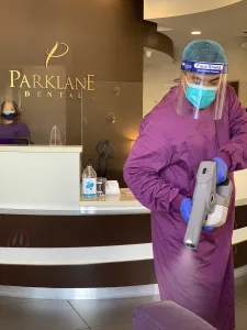 Miembro del equipo de Parklane Dental que realiza esterilización para el control de infecciones contra COVID en un centro dental en Arcadia, CA