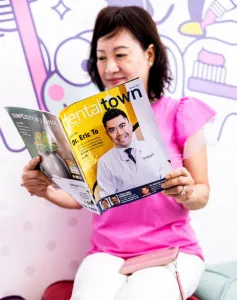 Mujer leyendo revista dental con el Dr.. Eric To de Parklane Dental