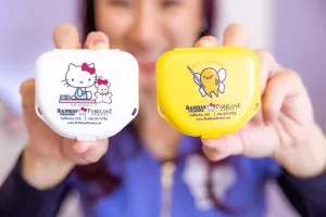 Cosmetic Dentist holding Hello Kitty and Gudetama dental case for Smile Makeover at Sanrio Friends x Parklane Dental in Temple City