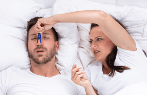woman pinching a mans nose closed