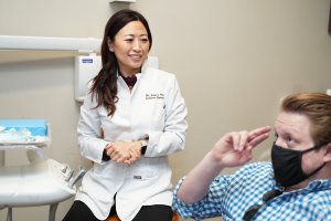 Dentista cosmético en una consulta de cambio de imagen de sonrisa con paciente adulto