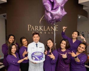 General and cosmetic dentist celebrating company anniversary with dental team