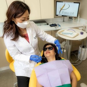 Cosmetic Dentist Dr. Mary He with female adult patient for Smile Makeover and dental exam at a dental operatory room