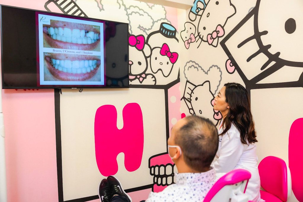 美容牙医与男性成年患者在 Hello Kitty 主题房间进行牙科植入物、牙套和牙冠的微笑改造咨询