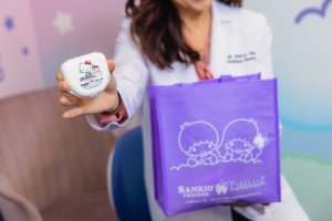 美容牙医博士. Mary He holding a Hello Kitty dental case for Take-Home Teeth Whitening Kit and a Little Twin Stars goodie bag