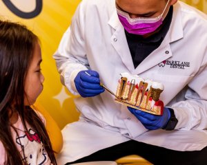 General dentist showing gum disease and cavity to a pediatric female patient with Gudetama room