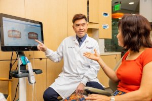 美容牙医与成年女性患者在阿卡迪亚的 Parklane Dental 审查 Invisalign 的微笑模拟, 加利福尼亚州